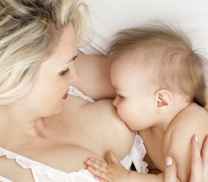 mother breast feeding her child, focus on the child